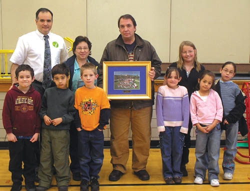 Louies Pizza owner Louie Sciarrotta (holding plaque) and his
wife Dawn join Pike Elementary Principal Manuel Ramsey
and students (from left) Sidney Gaylord, Cristian Medranda,
Matthew Flemming, Amber Pullara, Kimberly Loucks, Joslyn
Schwindt and Chelsey Martinez at an assembly Jan. 17 in which the businessman was thanked for donating monthly pizzas to the school for many years.
Hillary Pohlmann photo