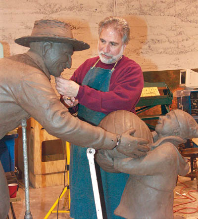 Fred Darpino works on a portion of the statue, which 
depicts Nick Venetucci helping a youngster with a large pumpkin.
