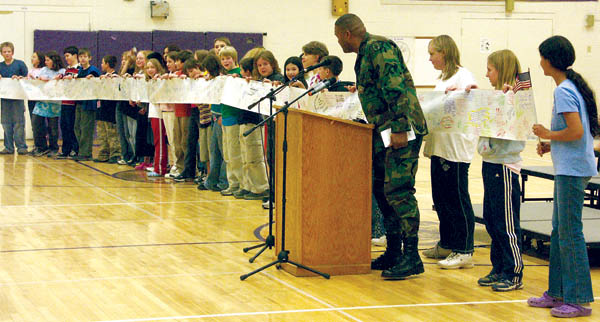 James Logan (at lectern) watches admiringly during his farewell assembly March 10 as students unroll a roughly 50-
foot-long paper sheet filled with comments from well-wishing West Middle School students.
Westside Pioneer photo