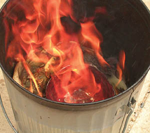 A pot from the kiln, immersed in the garbage can flames.