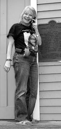 Standing on the front steps of the Bancroft cabin, event
organizer Lynda Dunne is clad in Territory Days battle
dress  including sneakers, this years festival T-shirt, cell phone and duct tape.
Westside Pioneer photo
