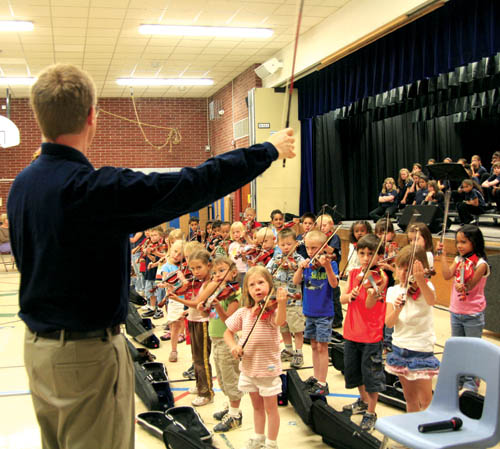 Michael Hanson of the Colorado Springs Philharmonic
Orchestra, Bristol Elementarys Suzuki violin teacher,
readies some of his youngest students for a song as part of the afternoon Honor Concert May 20 in the school gym. There was another concert in the evening.
Westside Pioneer photo