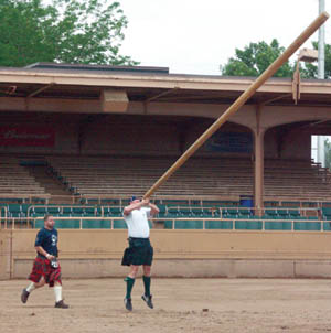 Mark Buchanan, a Coronado High track coach, tosses the caber during heavy athletics competition in 
Penrose Stadium, monitored by judge Hank Bradshaw