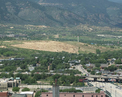 In a view looking west from the roof of a downtown 
building, Gold Hill Mesas smokestack and long-time drainage scars can be seen in the center of the photo. In the 
foreground is Colorado Avenue going under I-25.