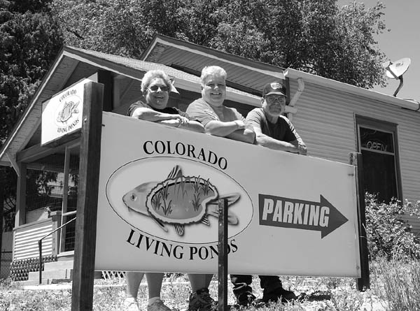 Colorado Living Ponds owners (from left) Terry Rudolph and Deb and Greg Kopchak stand behind a recently erected 
sign outside the building they are buying at 3404 W. Colorado Ave.
Westside Pioneer photo