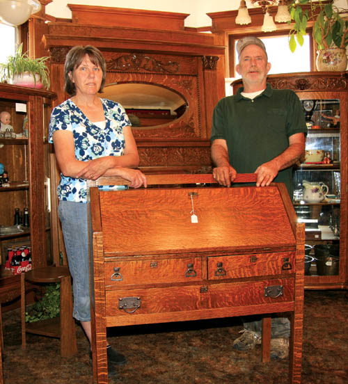 Darlene and Joe Roina stand with some of the wood furniture pieces Joe has restored for their Jug & Basin antique store.
Westside Pioneer photo