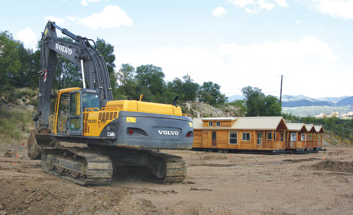 Some of the cabin-style RVs that are available with lot sales
in the Foot of the Rockies RV Resort development can be
seen, resting on one of the tiers that have been created
with earth-moving machines like the one in foreground. Nice
views are part of what the resort ownership is marketing in the development off Garner Street  such as the vista of the Garden of the Gods (far right, background).
Westside Pioneer photo