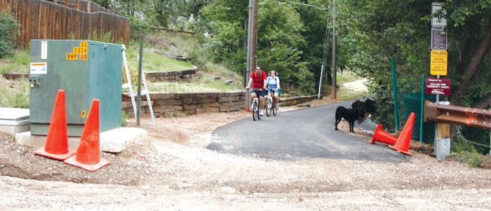 Westbound bicyclists  approach Holland Park Boulevard from the Douglas Creek Open Spaces Sinton Trail this 
week. Someone had pushed aside the citys Trail Closed sign at that location at the time, but many people have been using the newly paved trail anyway.
Westside Pioneer photo