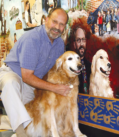 Bristol Principal Steve Ferguson dutifully poses with his dog
Tigger next to the painting of themselves in the 54-foot-long mural that was created on a school wall by the late Kathy Halstead Barnes in 2000. An inside joke is the 
elf Barnes painted onto Fergusons tie  a reminder of his dress-up character every Christmas at the school.
Westside Pioneer photo