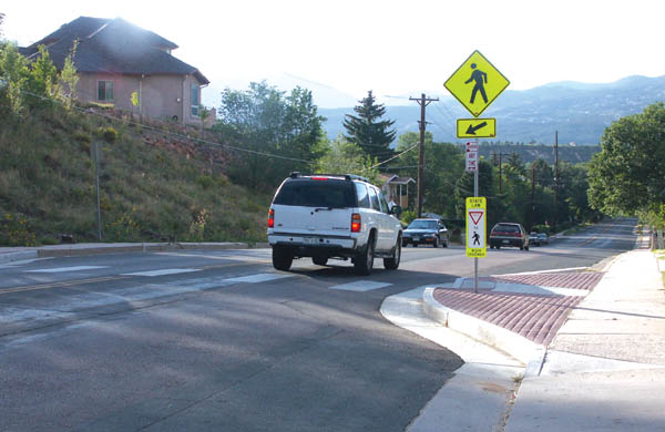 A car crests the Uintah hill at the recently built crosswalk/ bumpout near the Katharine Lee Bates Apartments. A proposed 
Uintah project would create sharrow lanes in which bicylists could use part of the traffic lane each way.
Westside Pioneer photo