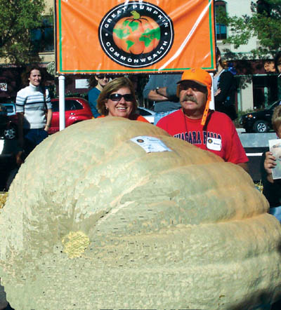 ABOVE: Rich Weatherbee, who lives on the Westside,
demonstrated carving techniques for onlookers during the
Giant Pumpkin Weigh-off. Inset photo shows one of his
creations during the afternoon. RIGHT: Joe and Michelle
Scherber are barely visible behind Joes first-place, 
1,008-pound pumpkin.
Colton Anderson photo