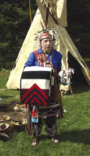 Standing in front of one of the two teepees erected for the occasion on the Orchard House lawn, Eugene Redhawk 
Orner shows the gifts he received from City Parks.
Westside Pioneer photo