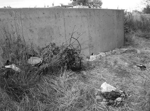 At a camp where one homeless person shot another in the
summer of 2007 next to Fountain Creek behind the
Westsides Sonic restaurant, some typical camp  debris can be seen  an empty liquor bottle, campfire ring, trash and discarded clothes.
Westside Pioneer file photo