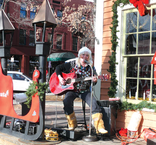 Jan Dixon performs outside the Garvin Cabin (decked out for Santa during the Christmas season), as part of the 
Holiday Magic festivities Nov. 28.
Westside Pioneer photo